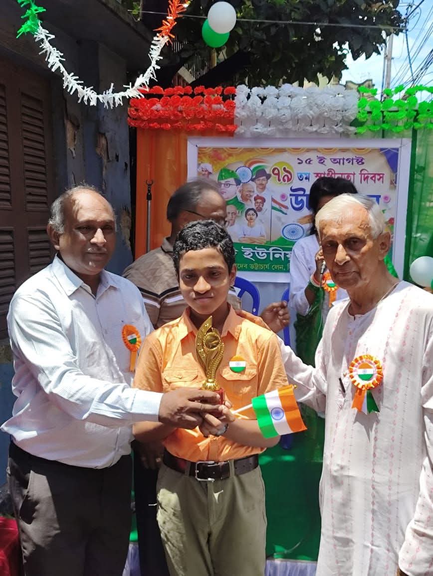 A young member receiving a trophy from club elders at the Independence Day programme